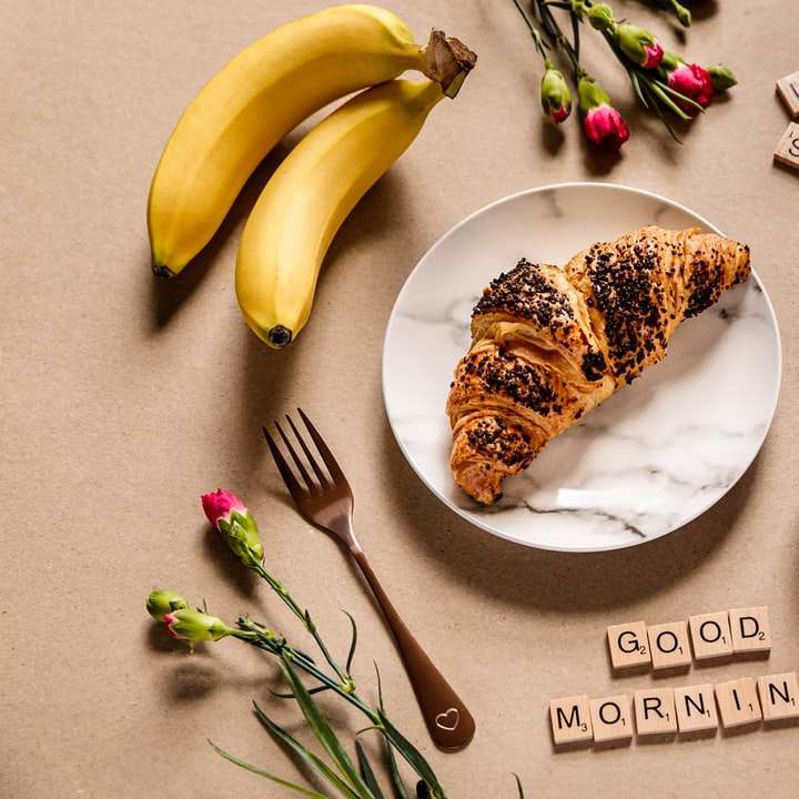 Fruta y pan del plátano en la placa de cerámica blanca. puzzle deslizante online