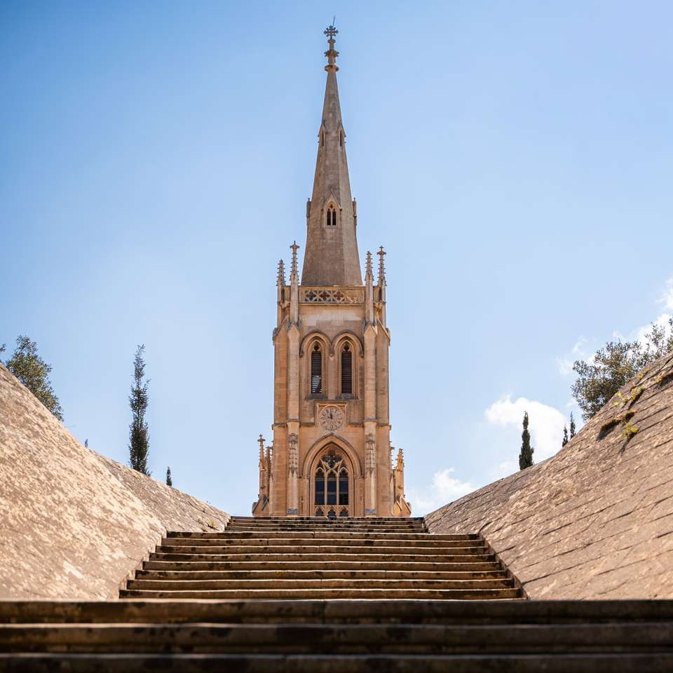 коричнева бетонна церква під блакитним небом вдень онлайн пазл