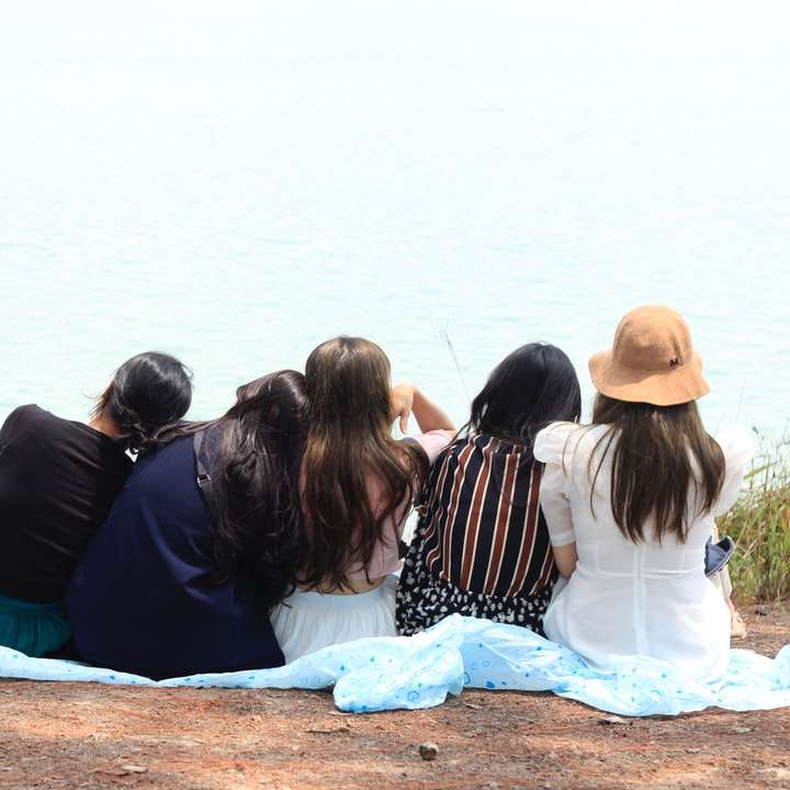 水域の近くの茶色の砂の上に座っている3人の女性 スライディングパズル・オンライン