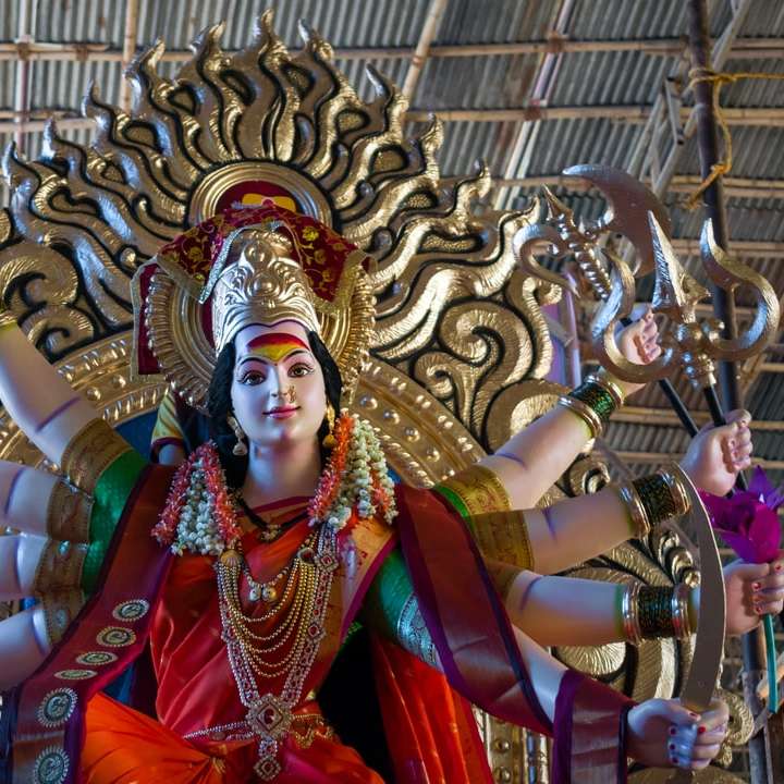 Statua bóstwa hinduskiego przed brązowym budynkiem puzzle przesuwne online