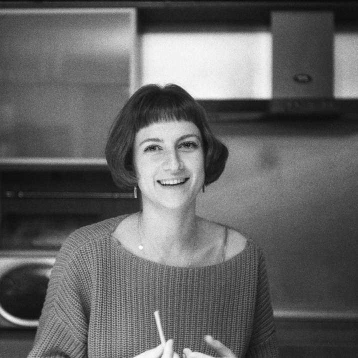 Mujer en suéter sonriendo en fotografía en escala de grises rompecabezas en línea