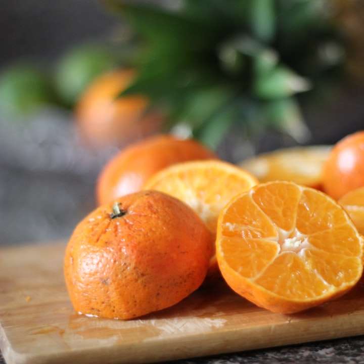 Skivad orange frukt på brunt träbricka glidande pussel online
