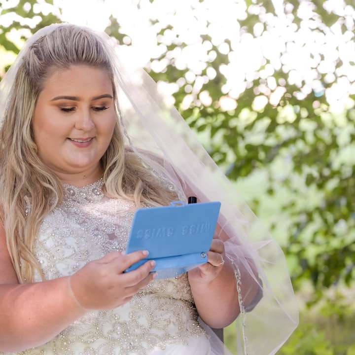 Mujer sonriente que sostiene la tableta azul rompecabezas en línea