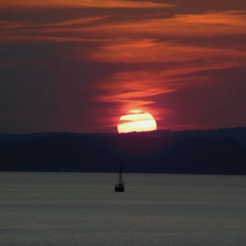 Silhouet van persoon die zich op overzeese kust bevindt tijdens zonsondergang schuifpuzzel online