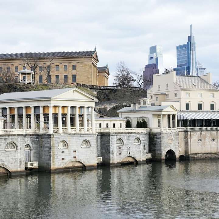 Bílá a hnědá betonová budova vedle řeky posuvné puzzle online