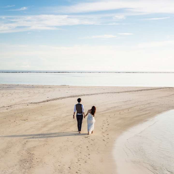2 жінки і чоловік гуляють по пляжу вдень онлайн пазл