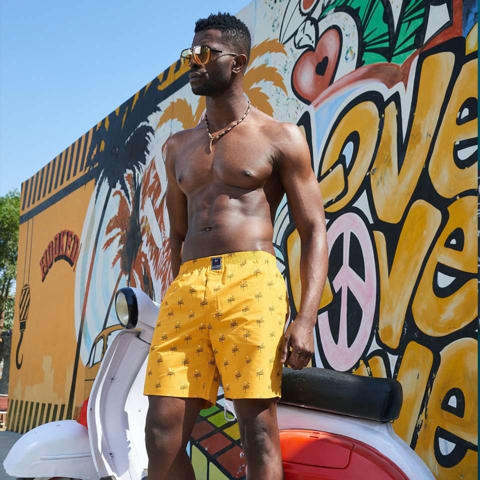 man in yellow and red shorts standing beside graffiti wall sliding puzzle online