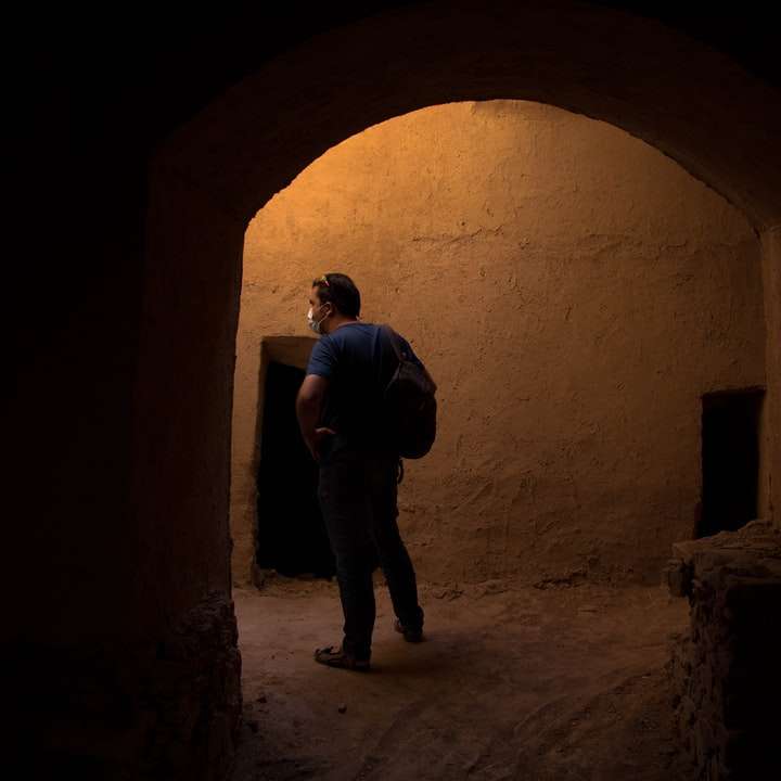човек в черно яке и панталони, стоящи в тунел плъзгащ се пъзел онлайн