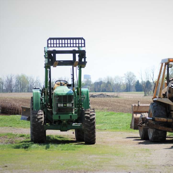 Groene en gele tractor op groen grasveld overdag schuifpuzzel online