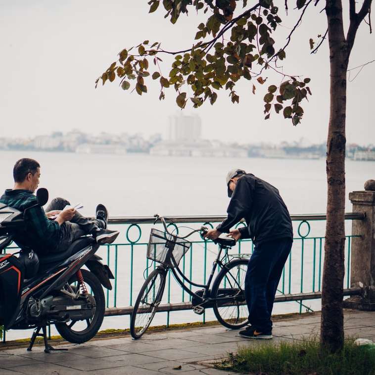 Mann und Frau, die auf dem Motorrad in der Nähe von Wasser des Wassers reiten Schiebepuzzle online