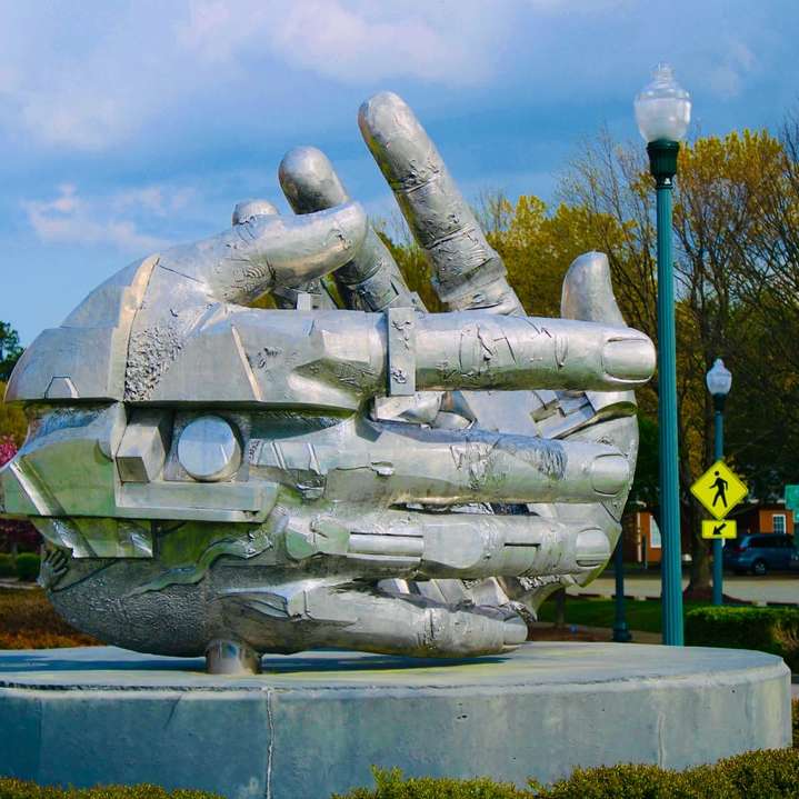 Szary betonowy statua blisko błękitnego metalowego ogrodzenia w ciągu dnia puzzle przesuwne online