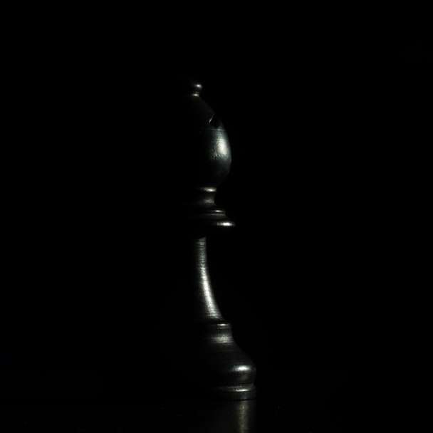 черная деревянная шахматная фигура на черной поверхности онлайн-пазл