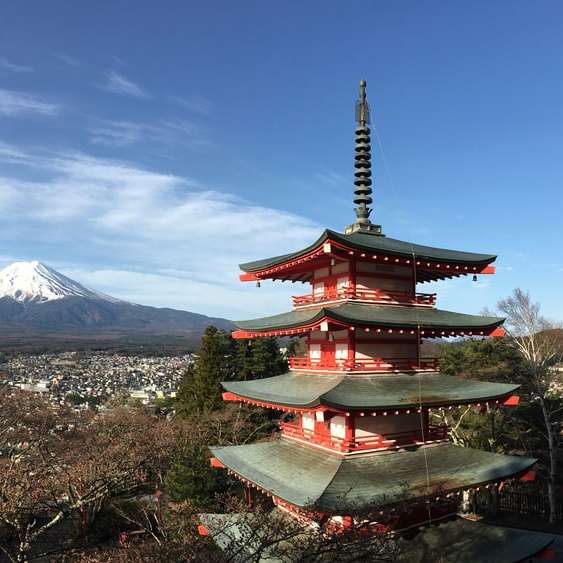 red and white temple near mountain under blue sky online puzzle