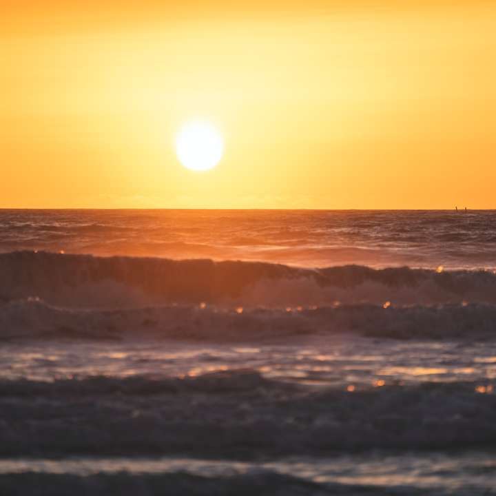 Vlny oceánu havarovat na břehu při západu slunce online puzzle