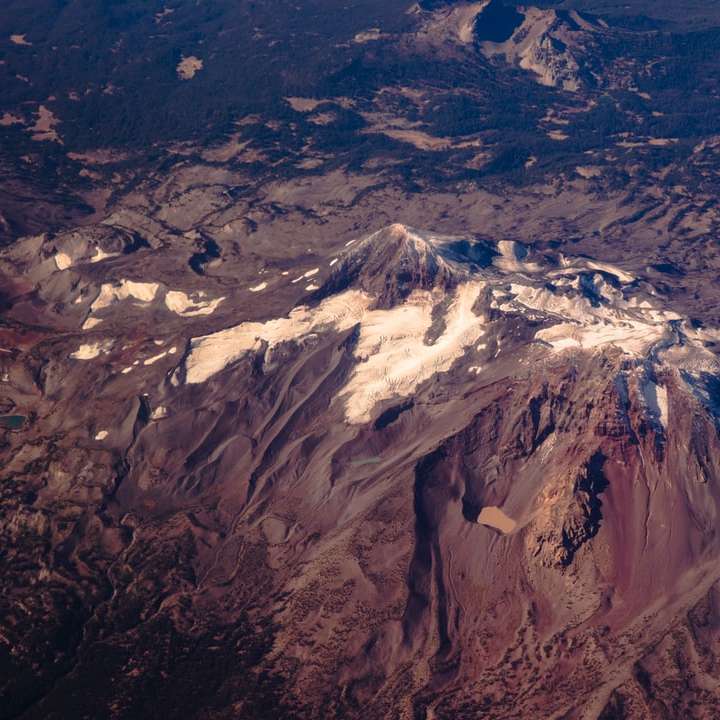 Montagna marrone e bianca sotto le nuvole bianche durante il giorno puzzle scorrevole online
