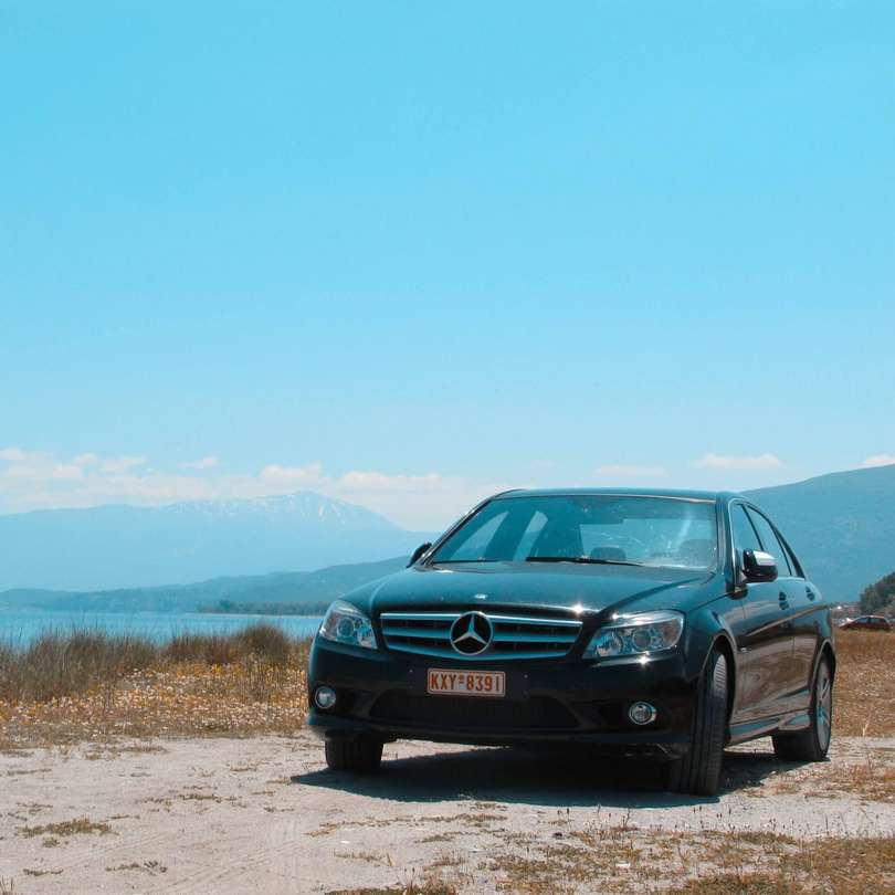 Zwarte BMW-auto op onverharde weg overdag online puzzel