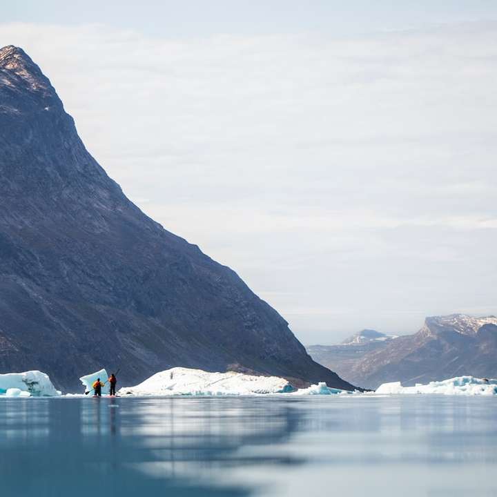 Бяла лодка на вода близо до планината през деня онлайн пъзел