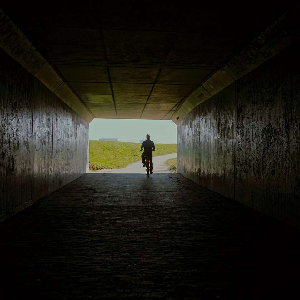 man in black jacket walking on tunnel sliding puzzle online