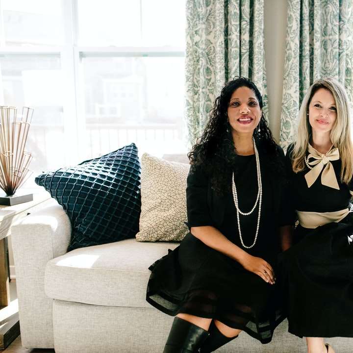 2 kobiety w czarnej sukni siedzi na kanapie puzzle online