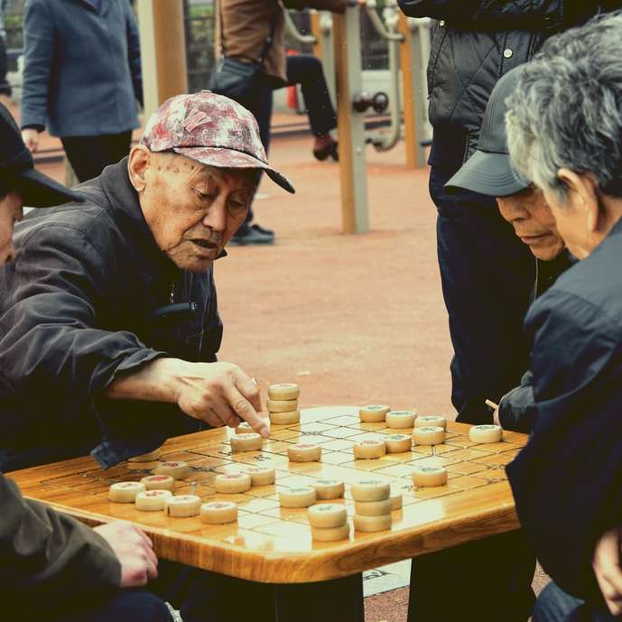 Homem, em, jaqueta preta, jogando xadrez puzzle deslizante online