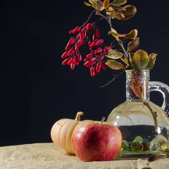 Κόκκινα φρούτα μήλου δίπλα σε σαφή κανάτα συρόμενο παζλ online