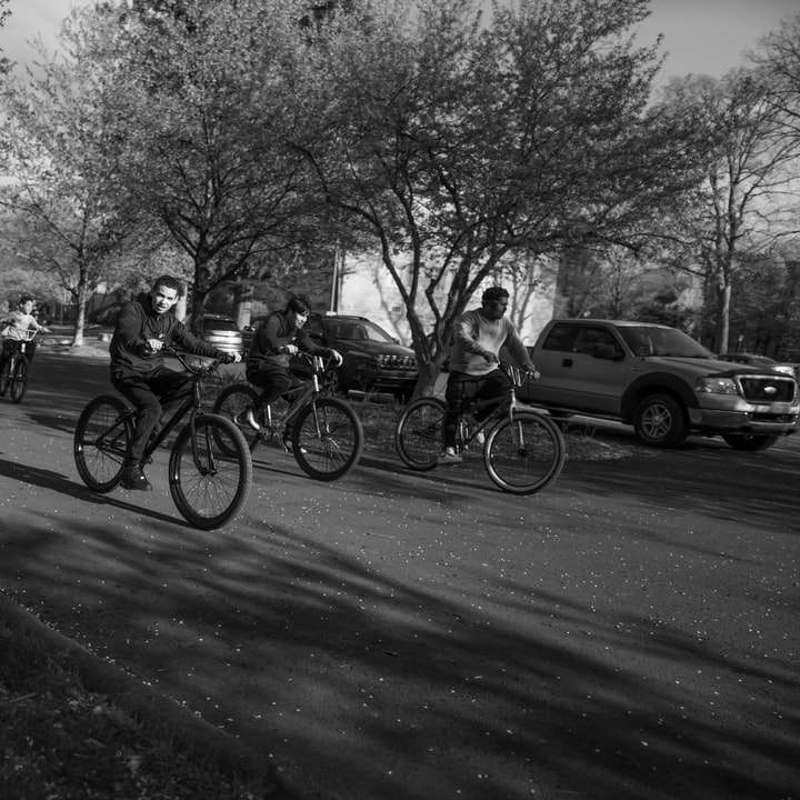 Фотография людей, едущих по дороге на велосипедах в оттенках серого раздвижная головоломка онлайн