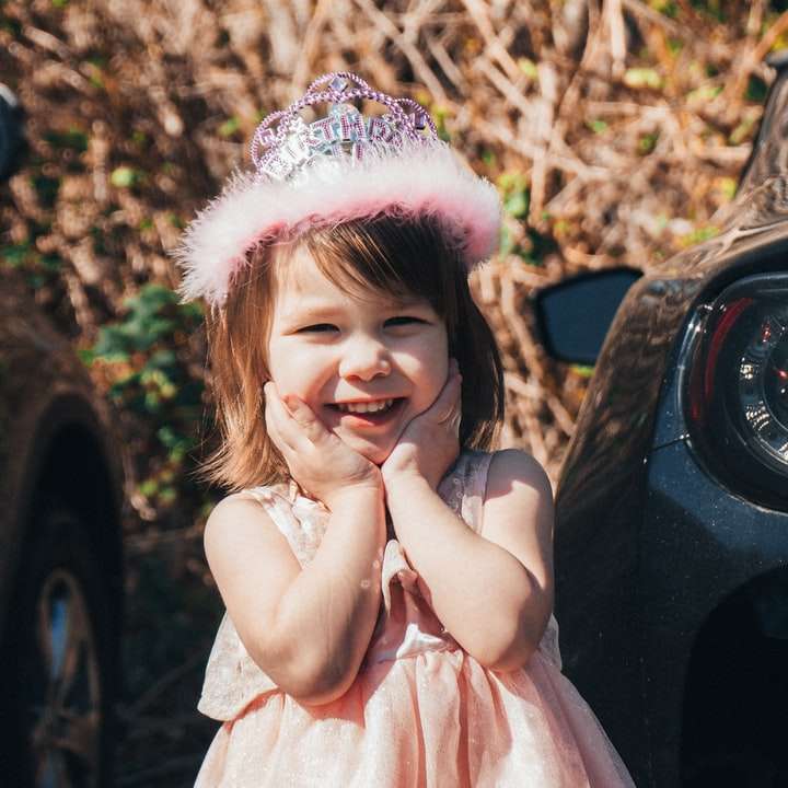Κορίτσι σε ροζ φόρεμα κάθεται σε μαύρο αυτοκίνητο online παζλ