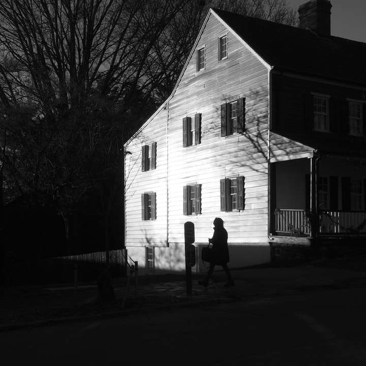 2 personer som står framför vitt och brunt hus Pussel online