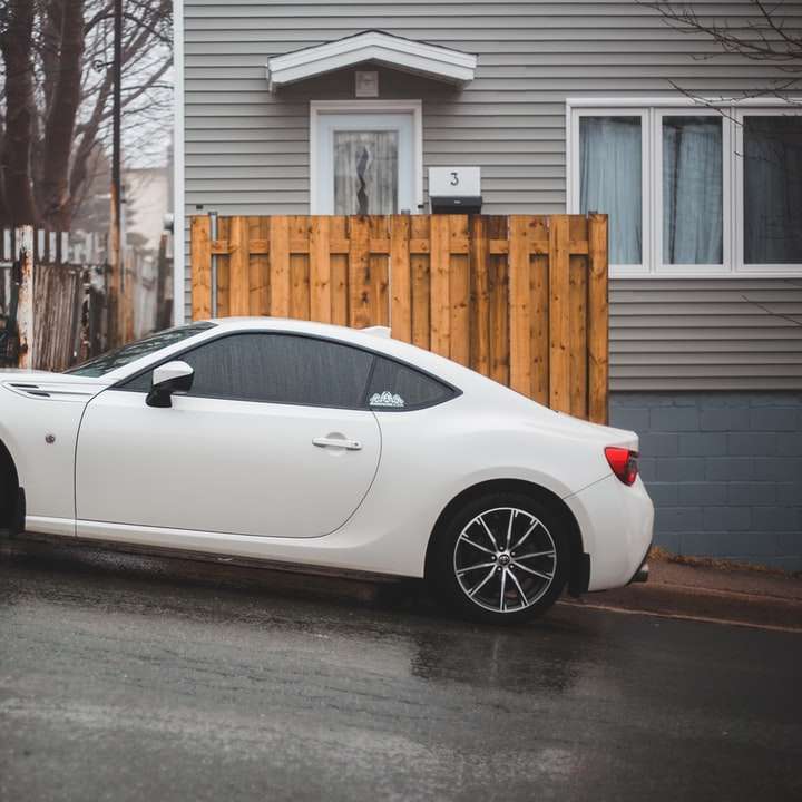 bílé porsche 911 zaparkované poblíž hnědého dřevěného plotu online puzzle