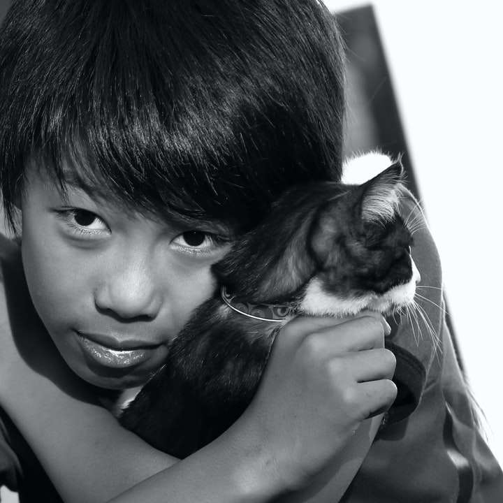 foto en escala de grises de niño sosteniendo cachorro rompecabezas en línea