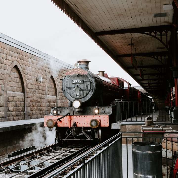 κόκκινο και μαύρο τρένο στις σιδηροδρομικές γραμμές κατά τη διάρκεια της ημέρας συρόμενο παζλ online