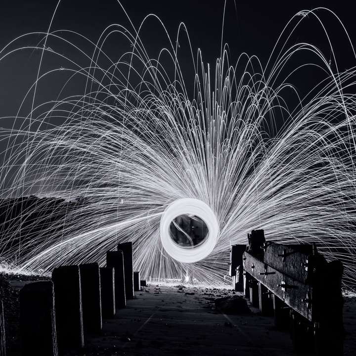 steel wool photography of a man standing on a bridge online puzzle