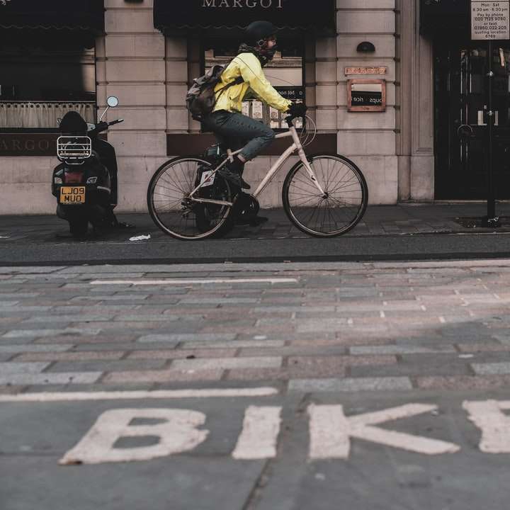 Mann im gelben Hemd, der Fahrrad auf Bürgersteig fährt Schiebepuzzle online