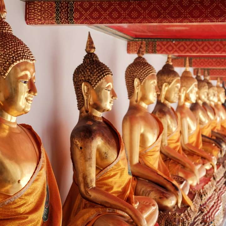 Estatua de Buda de oro sobre textil rojo y blanco. puzzle deslizante online