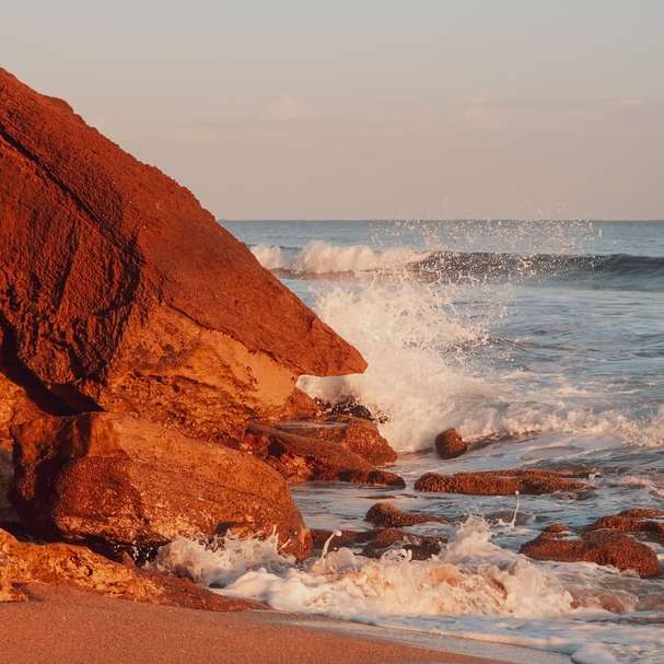 brązowa formacja skalna w pobliżu morza w ciągu dnia puzzle przesuwne online