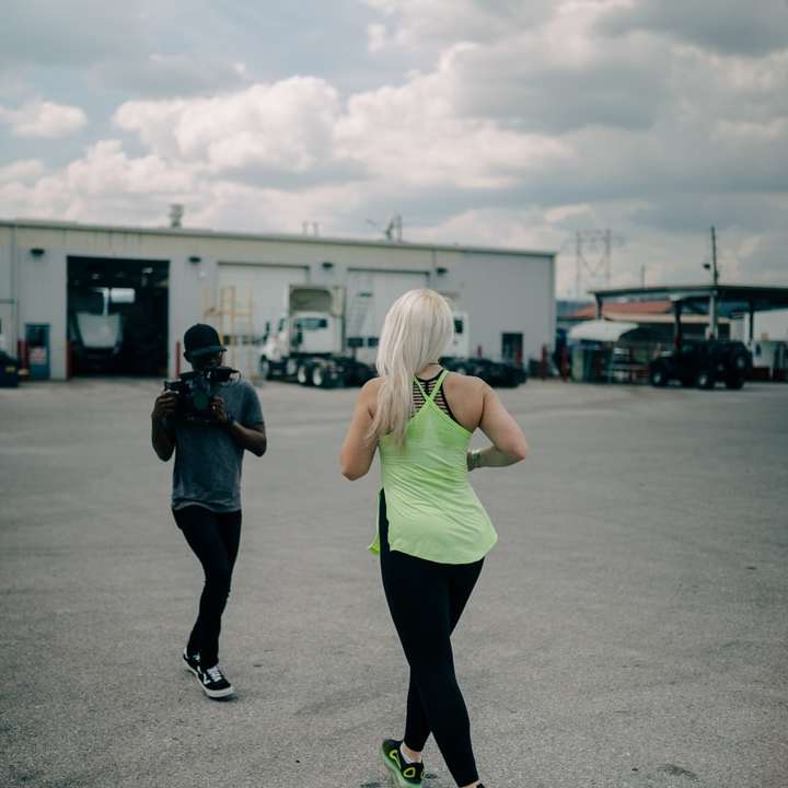 woman in green tank top and black leggings standing on road online puzzle