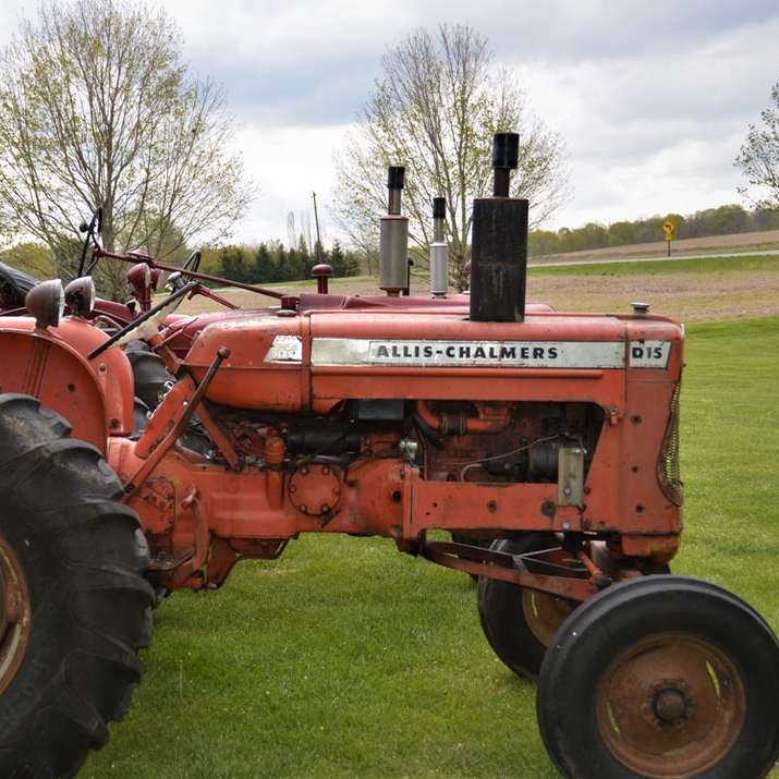 czerwony traktor na zielonym polu trawy w ciągu dnia puzzle online