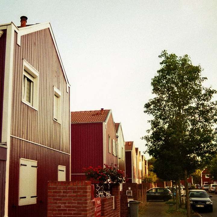 rotes und weißes Holzhaus in der Nähe von grünen Bäumen tagsüber Schiebepuzzle online