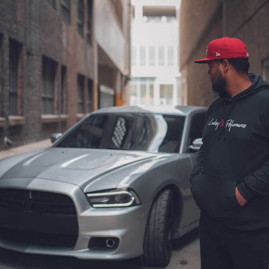 άνδρας με μαύρο σακάκι που στέκεται δίπλα σε ασημί αυτοκίνητο συρόμενο παζλ online