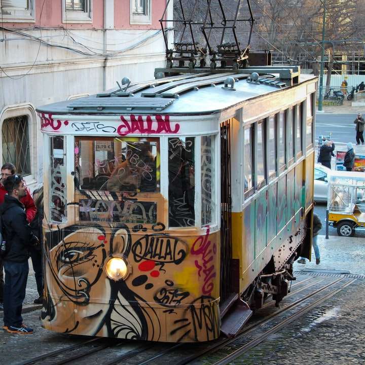 personnes debout à côté du tram jaune et blanc pendant la journée puzzle en ligne