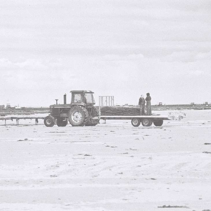 2 mężczyzn stojących obok ciężarówki na pokrytym śniegiem polu puzzle przesuwne online