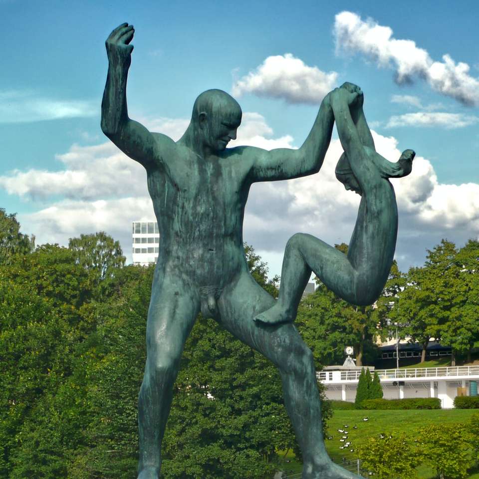 socha muže na zelené louce během dne posuvné puzzle online