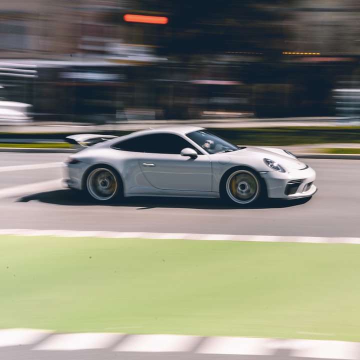 Porsche 911 blanco en la carretera durante el día rompecabezas en línea