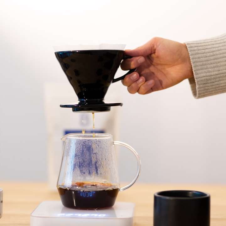 човек, който налива кафе върху кафе плъзгащ се пъзел онлайн