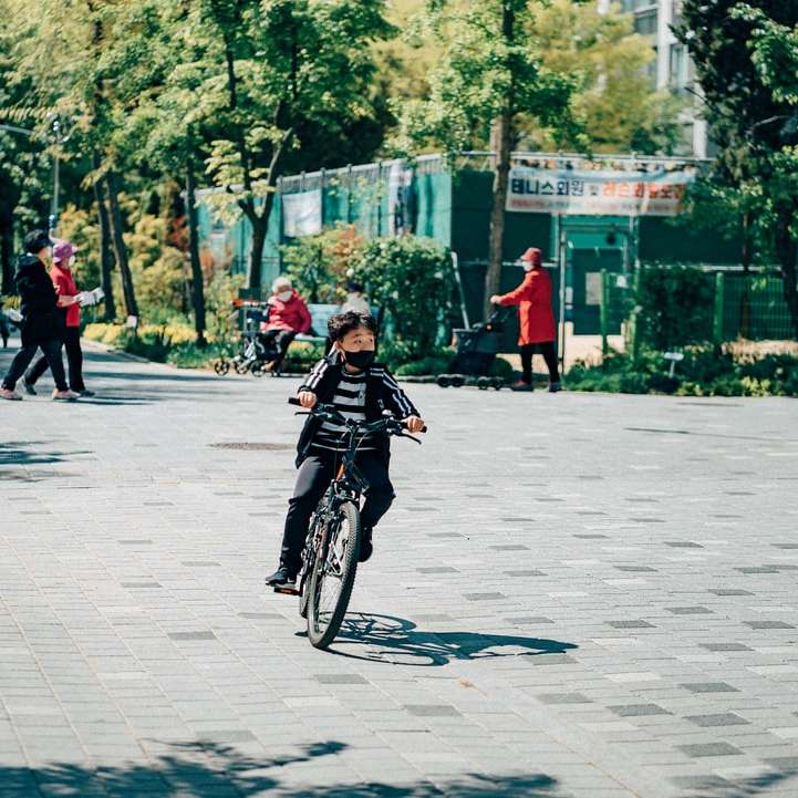 άντρας με μαύρο σακάκι ιππασία ποδήλατο στο δρόμο κατά τη διάρκεια της ημέρας online παζλ