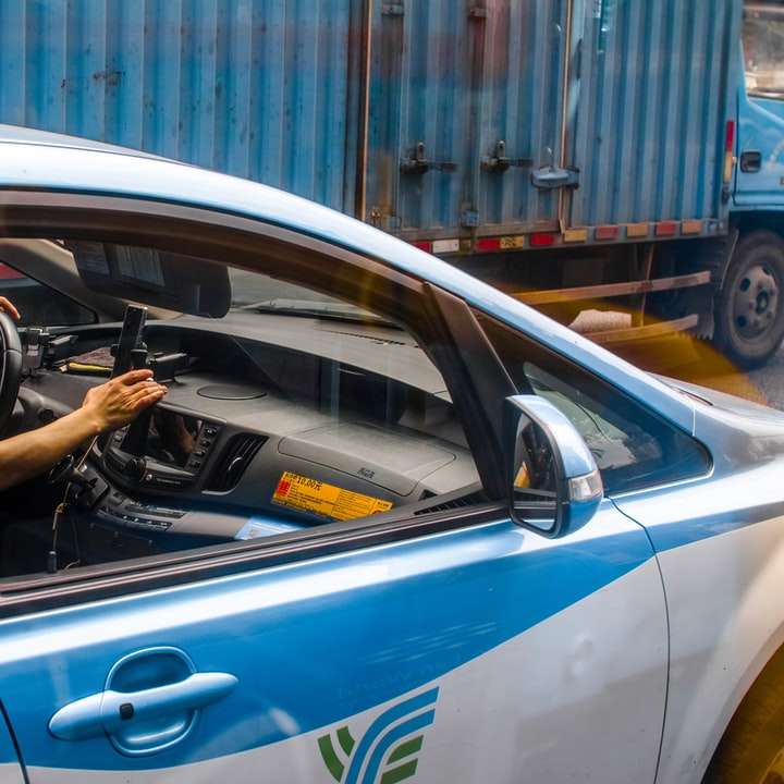 osoba prowadząca niebieski samochód w ciągu dnia puzzle online