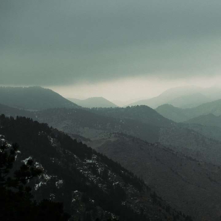 καταπράσινα βουνά κάτω από άσπρα σύννεφα κατά τη διάρκεια της ημέρας συρόμενο παζλ online