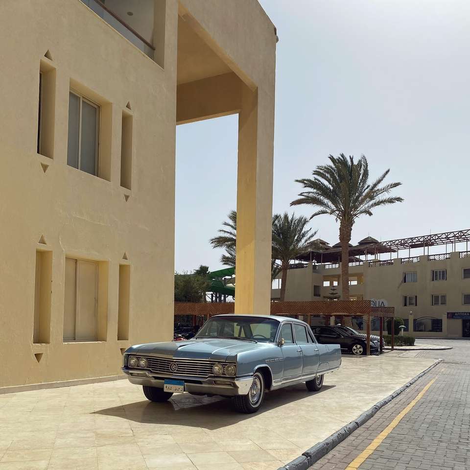 zwarte sedan geparkeerd naast beige betonnen gebouw online puzzel