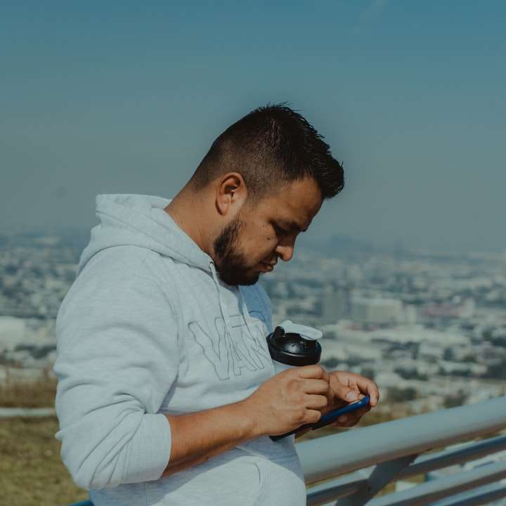 uomo in camicia bianca che tiene in mano una fotocamera reflex digitale puzzle online
