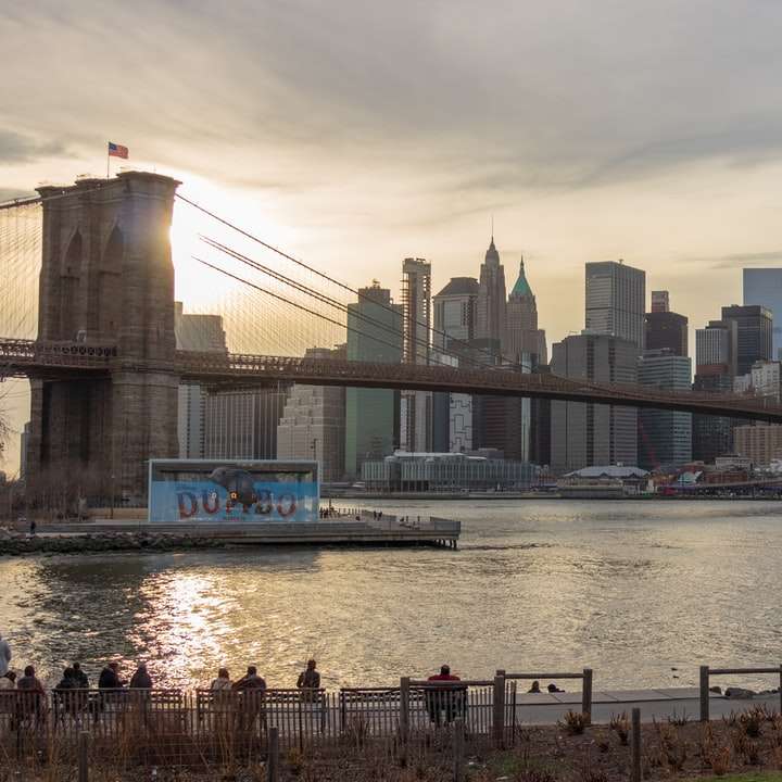 fehér és kék csónak a vízen híd közelében, nappal online puzzle